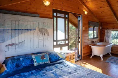a bedroom with a bed and a bath tub and a sink at Flock-Inn in Fisherhaven