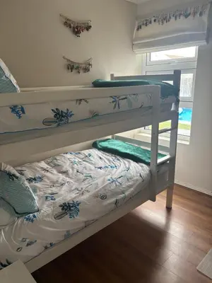 two bunk beds in a room with a bed at Family Home in West Beach, Blouberg in Cape Town