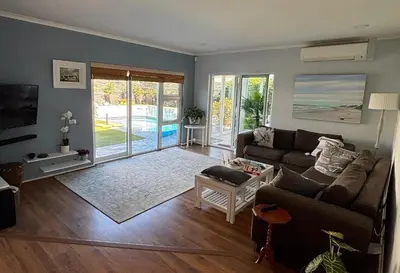 a living room with a couch and a tv at Family Home in West Beach, Blouberg in Cape Town