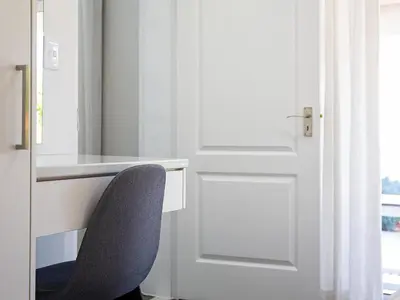 a chair sitting at a desk next to a door at La Dolce Vita Gordon’s Bay in Gordonʼs Bay