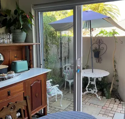 a patio with an umbrella and a table and chairs at Somerset West All Stay 3 in Somerset West