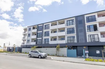 a car parked in front of a building at Sunny Beach Apartment with Sea & Mountain Views in Cape Town