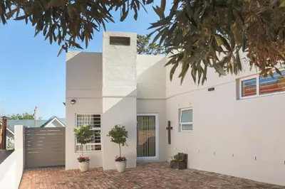 a white house with a cross on the side at Inn 201 in Hermanus