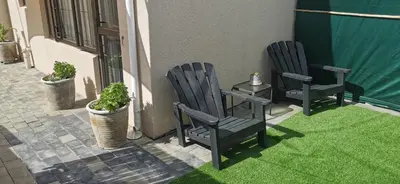 two blue chairs sitting on a patio with green grass at Mila's at Panorama in Panorama