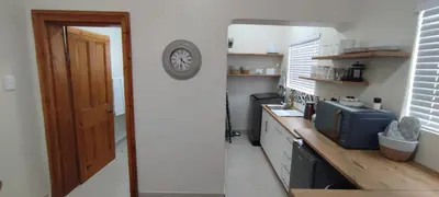 a kitchen with a counter and a clock on the wall at Lasai Accommodation in Worcester