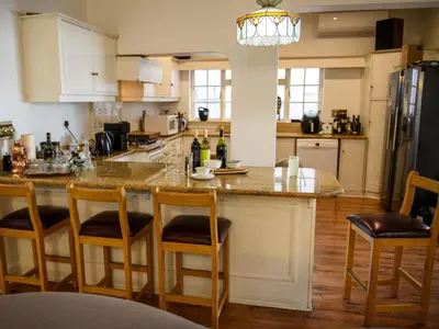 a kitchen with a large island with bar stools at Petites Bulles Lodge in Stellenbosch