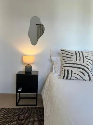 a bedroom with a bed with a lamp on a night stand at Chasselas Self Catering in Cape Town
