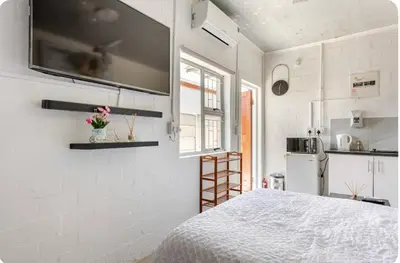 a white kitchen with a bed in a room at A Room with private Entrance in Cape Town