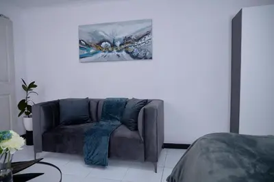 a couch in a room with a painting on the wall at Blomtuin Sleep and go room in Cape Town