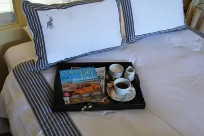 a tray with a book and a cup of coffee on a bed at Piece of Paradise in Cape Town