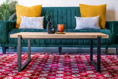 a living room with a green couch and a wooden coffee table at 9 On The Waves in Cape Town