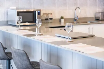 a kitchen with three wine glasses on a counter at 9 On The Waves in Cape Town