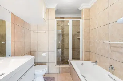 a bathroom with a tub and a toilet and a sink at 9 On The Waves in Cape Town