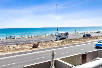 a truck driving down a road next to the beach at 9 On The Waves in Cape Town