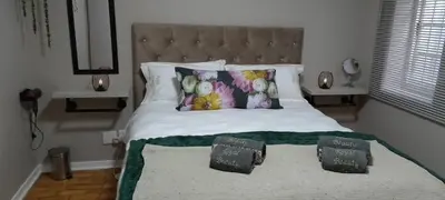 a bedroom with a bed with two pillows on it at Royal Beauty in Paarl