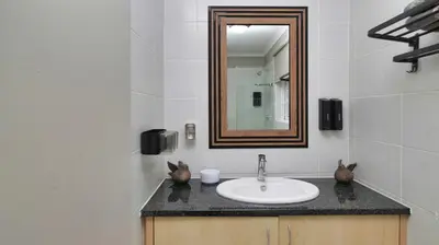 a bathroom with a sink and a mirror at Royal Beauty in Paarl