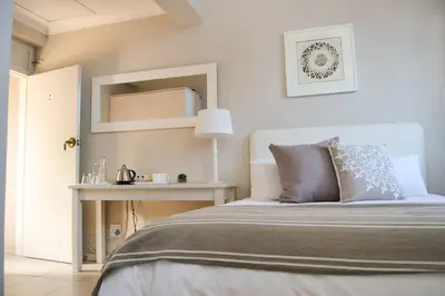 a bedroom with a bed and a table with a lamp at Olive Grove on Provident in Cape Town