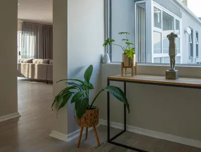 a living room with a plant and a table at Twin Gables, centrally located 2 bedroom apartment in Hermanus