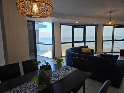 a living room with a view of the ocean at Ocean View 304 Luxury Self Catering Apartment Strand Western Cape South Africa in Cape Town
