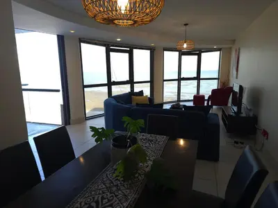 a living room with a blue couch and a table at Ocean View 304 Luxury Self Catering Apartment Strand Western Cape South Africa in Cape Town