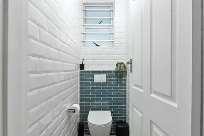 a bathroom with a toilet and a window at ZenDen Destinations' Tidal Tranquillity in Cape Town