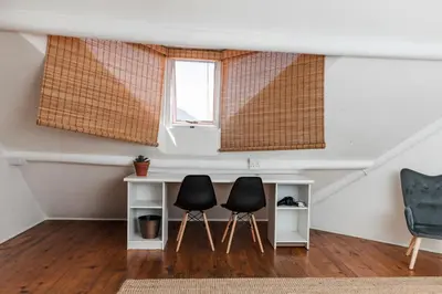 a room with two chairs and a desk and a window at Silvertree Collective Spacious Central Apartment in Stellenbosch