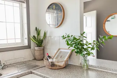 a kitchen counter with a clock and a sink at Silvertree Collective Spacious Central Apartment in Stellenbosch