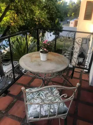 a table with a potted plant on a balcony at Gatsby Suite, with pool in quiet area, close to town in Stellenbosch