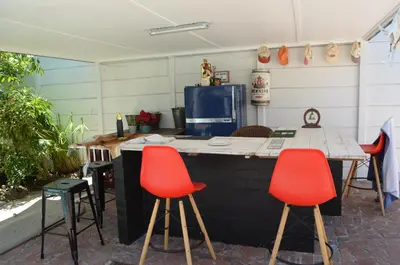 a kitchen with four red chairs and a table at Gatsby Suite, with pool in quiet area, close to town in Stellenbosch