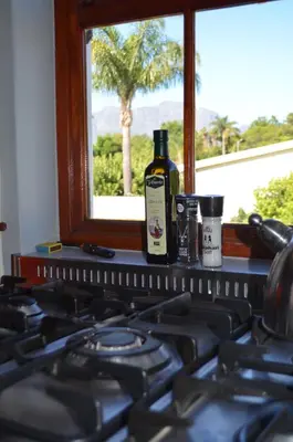 a bottle of wine sitting on a stove next to a window at Gatsby Suite, with pool in quiet area, close to town in Stellenbosch