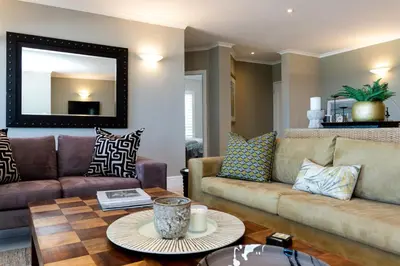a living room with a couch and a table at Lagoon Beach Penthouse in Cape Town