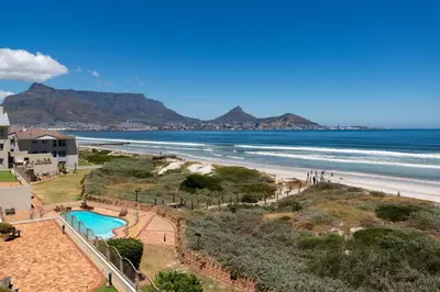 a view of a beach with a swimming pool and the ocean at Lagoon Beach Penthouse in Cape Town
