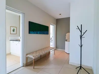 a room with a bench and a painting on the wall at Penguin View in Bettyʼs Bay