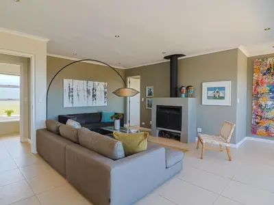 a living room with a couch and a fireplace at Penguin View in Bettyʼs Bay