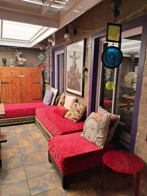 a living room with red couches in a room at Listening Wind Self-Catering accommodation in Bettyʼs Bay