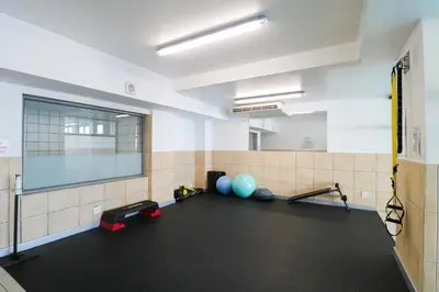 a room with a gym with weights and a large window at 1402 Hibernian Towers Luxury Self Catering Apartment Strand Western Cape South Africa in Cape Town