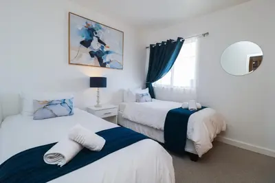 a bedroom with two beds and a mirror at 1401 Hibernian Towers Luxury Self Catering Apartment Strand Western Cape South Africa in Cape Town