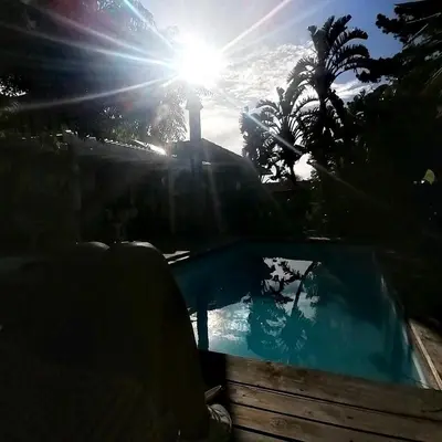 a swimming pool with the sun in the background at Aloha Lodge in Cape Town