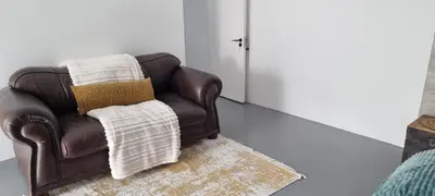 a brown leather chair with two pillows on a rug at Matt's Place in Cape Town