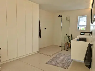 a bathroom with a shower and a white door at 'Kaya Moya' - Luxury Suite for 2 with Ocean Views in Gordonʼs Bay