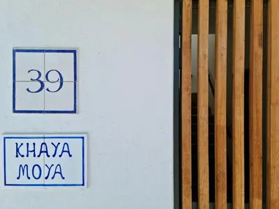 a white building with a sign on the side of it at 'Kaya Moya' - Luxury Suite for 2 with Ocean Views in Gordonʼs Bay