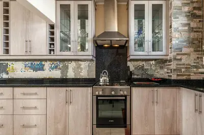 a kitchen with white cabinets and a stove top oven at Elegance on Beach in Cape Town