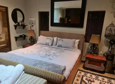 a bedroom with a bed with a mirror on the wall at Devon View Olive Farm in Stellenbosch