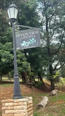 a street sign on a light pole in a park at Devon View Olive Farm in Stellenbosch