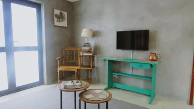 a living room with a television and a table with two chairs at Sonvanger 3 in Paarl