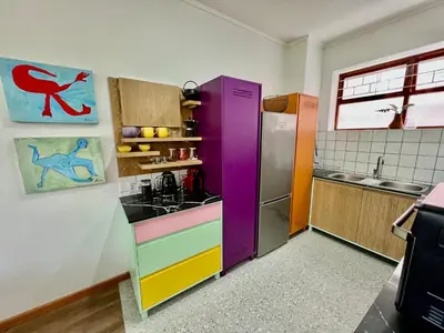 a kitchen with colorful cabinets and a refrigerator at 2 Bedroom Apartment On Dorp St - Prime Location in Stellenbosch