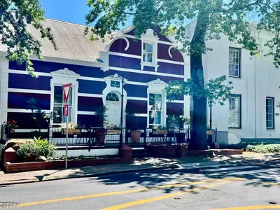 a blue and white house with a tree in front of it at 2 Bedroom Apartment On Dorp St - Prime Location in Stellenbosch
