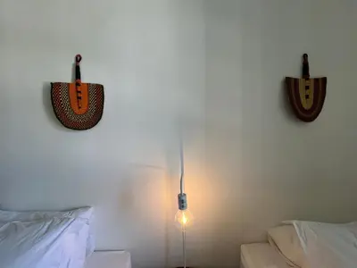 a bedroom with a bed and a light on the wall at 2 Bedroom Apartment On Dorp St - Prime Location in Stellenbosch
