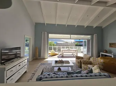 a living room with a couch and a tv at Fijnbos in Pringle Bay