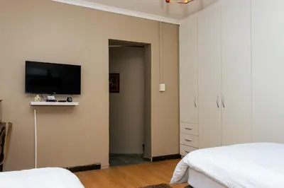 a bedroom with a flat screen tv on the wall at STAY In TEHAMA in Cape Town